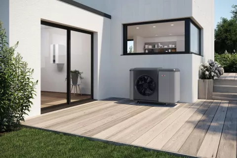 Eine Wärmepumpenheizung gut integriert vor einem modernen Einfamilienhaus.